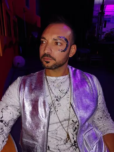 Blue and purple glitter glam around a guest's eye at an evening event