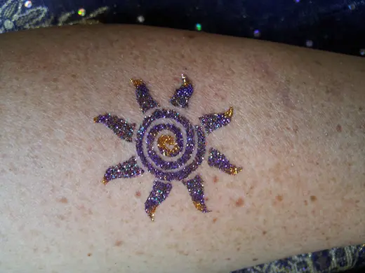 Purple and gold glitter sun on an arm