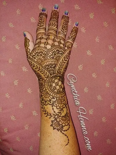 Henna mehndi covering the back of a hand and wrist, finished with a mandala at the wrist