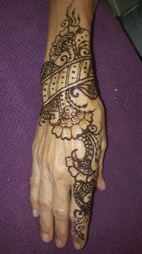 Henna cuff and paisley design wrapping the wrist and back of a hand
