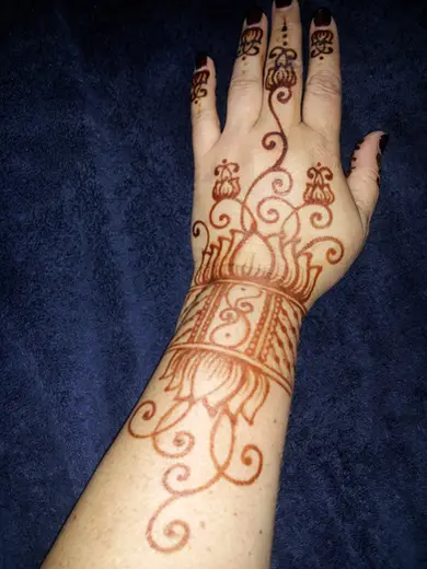 Henna cuff and lotus design on the wrist with fine vines running up the arm